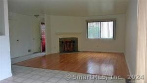 unfurnished living room with a fireplace and wood finished floors