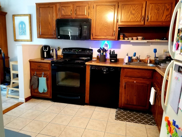 kitchen with brown cabinets, black appliances, open shelves, a sink, and light tile patterned flooring