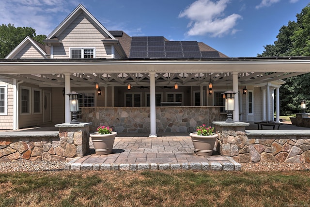 back of house featuring a patio area and solar panels