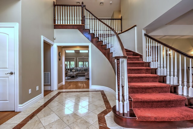 stairs featuring hardwood / wood-style floors and a high ceiling