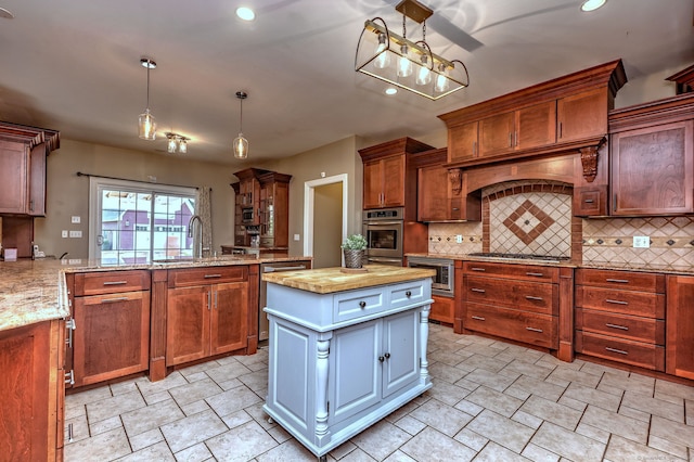 kitchen featuring pendant lighting, appliances with stainless steel finishes, a center island, kitchen peninsula, and sink