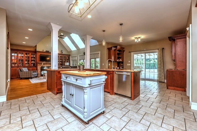 kitchen with dishwasher, decorative light fixtures, ornate columns, kitchen peninsula, and a kitchen island