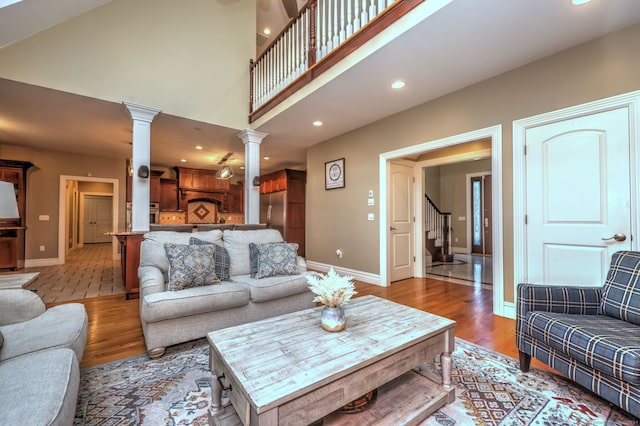 living room featuring hardwood / wood-style floors, a high ceiling, and decorative columns