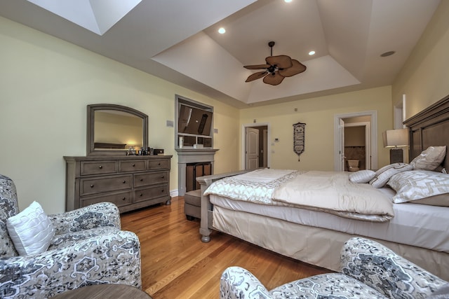 bedroom featuring a tray ceiling, ceiling fan, hardwood / wood-style floors, and vaulted ceiling