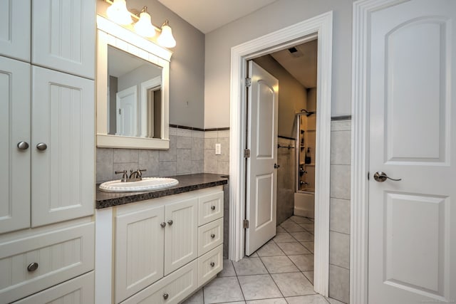 bathroom featuring vanity, backsplash, tile patterned flooring, tile walls, and shower / bathing tub combination