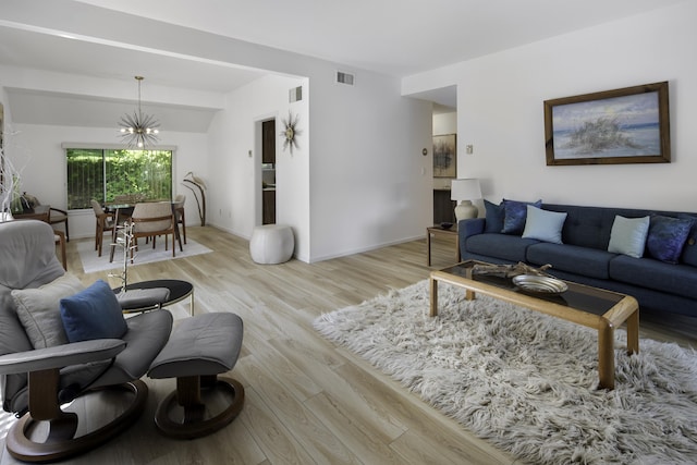 living room featuring light hardwood / wood-style flooring and a notable chandelier