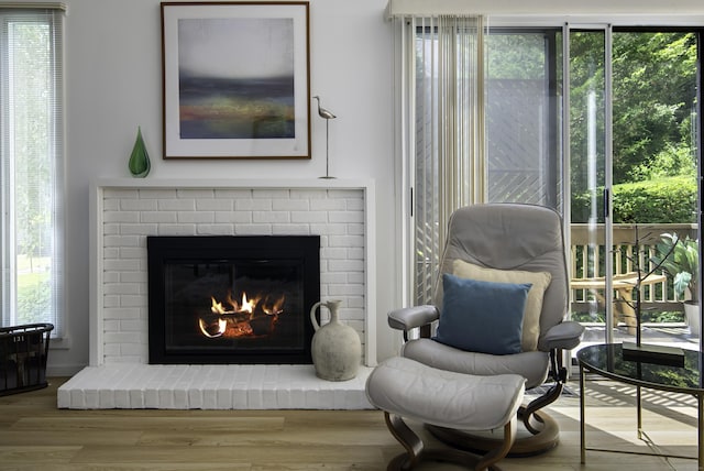 sitting room with plenty of natural light, a fireplace, and light wood-type flooring