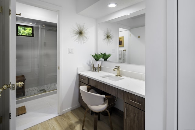 bathroom with vanity, a shower with shower door, and wood-type flooring