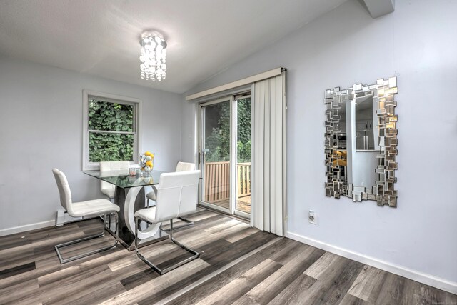 dining room featuring wood-type flooring, vaulted ceiling, and a chandelier