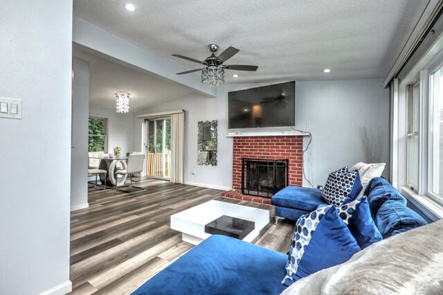 living room with a fireplace, vaulted ceiling, hardwood / wood-style floors, and ceiling fan