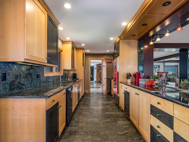 kitchen with sink, appliances with stainless steel finishes, decorative light fixtures, dark stone countertops, and light brown cabinetry