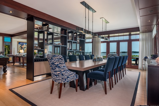 dining space featuring light hardwood / wood-style floors and a water view