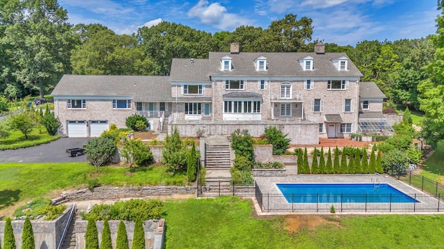 back of house with a yard and a fenced in pool