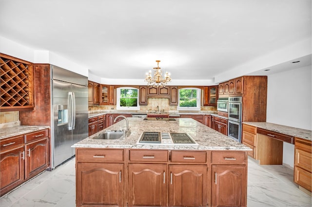 kitchen featuring appliances with stainless steel finishes, sink, light tile patterned floors, decorative backsplash, and a chandelier