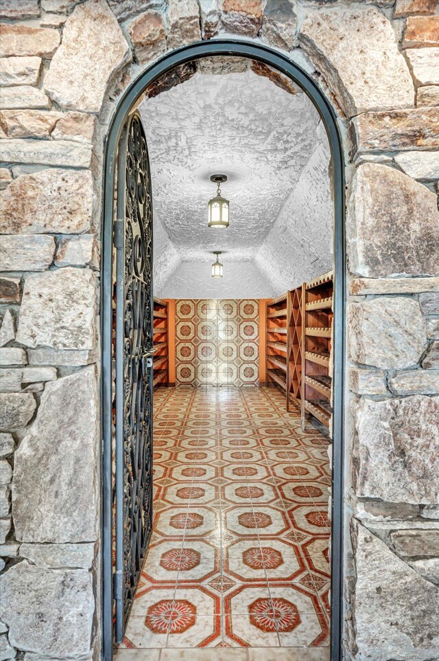 wine cellar with tile patterned floors and a textured ceiling