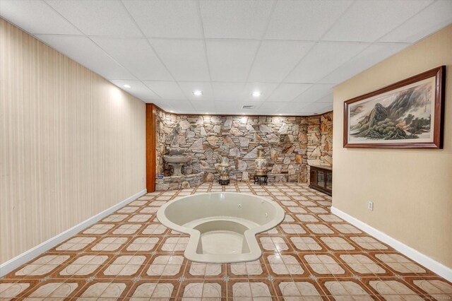 interior space featuring tile patterned flooring and a drop ceiling