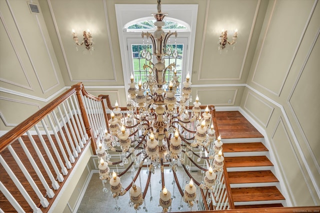 stairs featuring an inviting chandelier and wood-type flooring