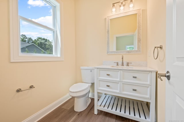 bathroom with hardwood / wood-style flooring, vanity, and toilet