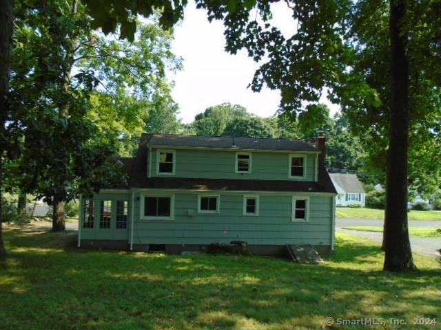 rear view of property featuring a lawn