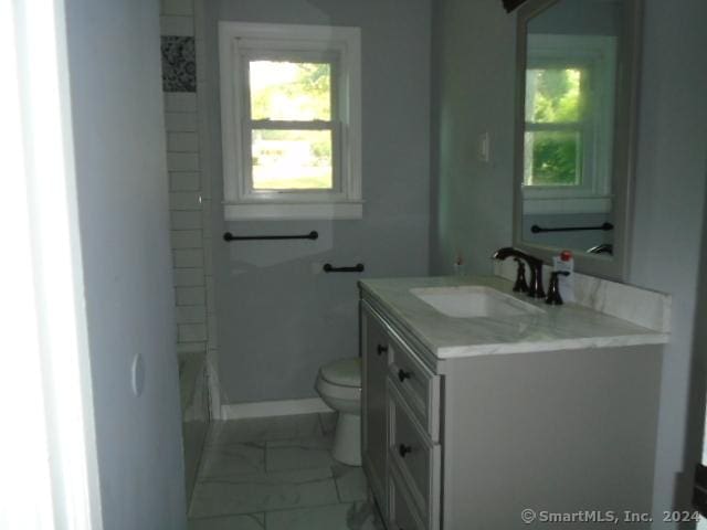 bathroom featuring vanity, toilet, baseboards, and marble finish floor