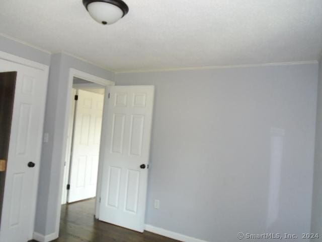 unfurnished room featuring dark wood-style floors and baseboards