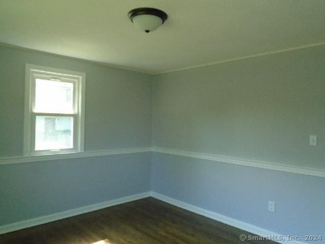 empty room featuring dark wood-style floors and baseboards