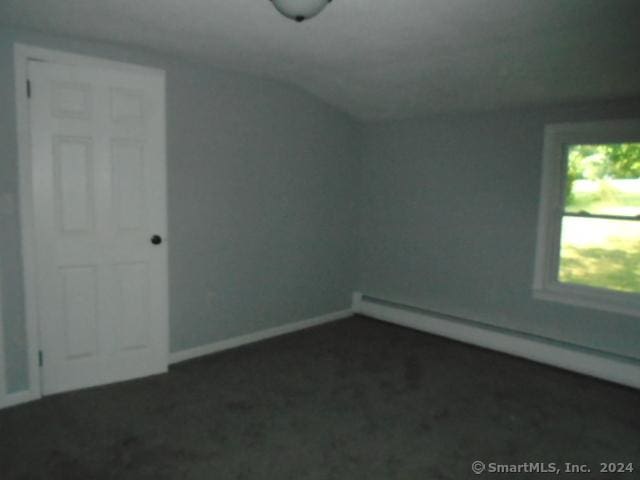 bonus room featuring baseboards, baseboard heating, dark carpet, and vaulted ceiling