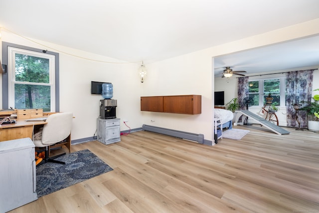 home office featuring light wood-type flooring, baseboard heating, and ceiling fan