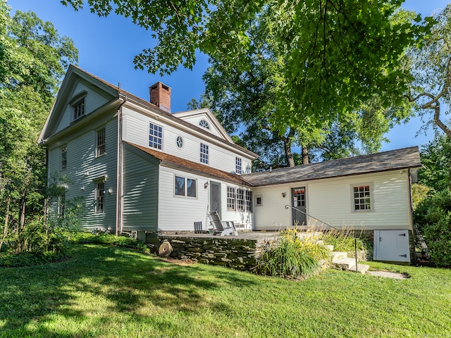 back of house featuring a lawn and a patio