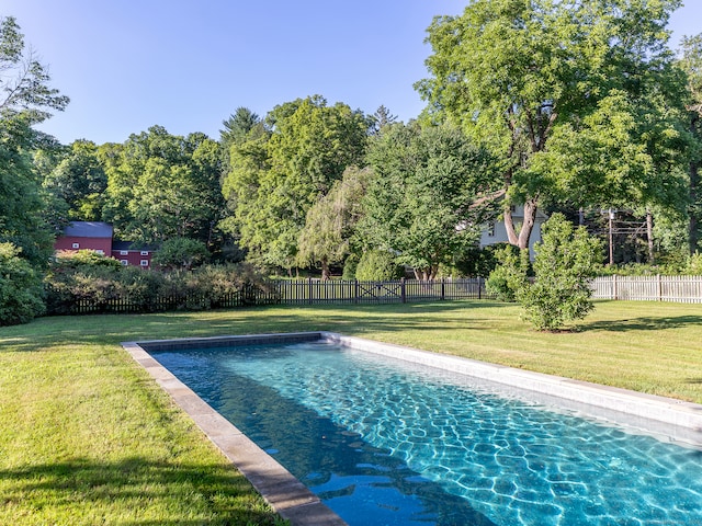 view of swimming pool with a yard