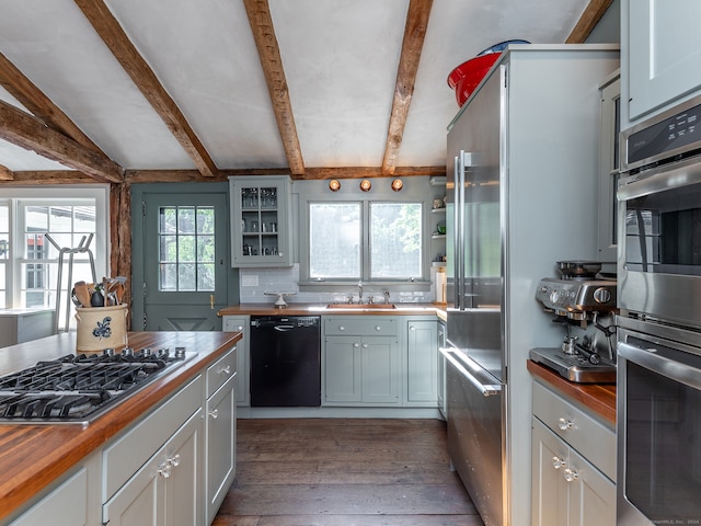 kitchen featuring a healthy amount of sunlight, butcher block countertops, sink, and stainless steel appliances