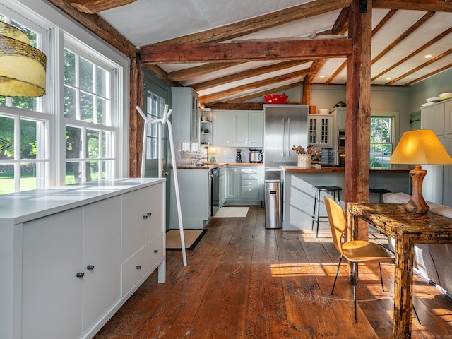 kitchen featuring white cabinets, lofted ceiling with beams, dark hardwood / wood-style floors, and plenty of natural light