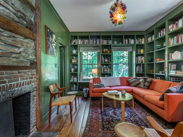 interior space with hardwood / wood-style flooring, a fireplace, crown molding, and built in features