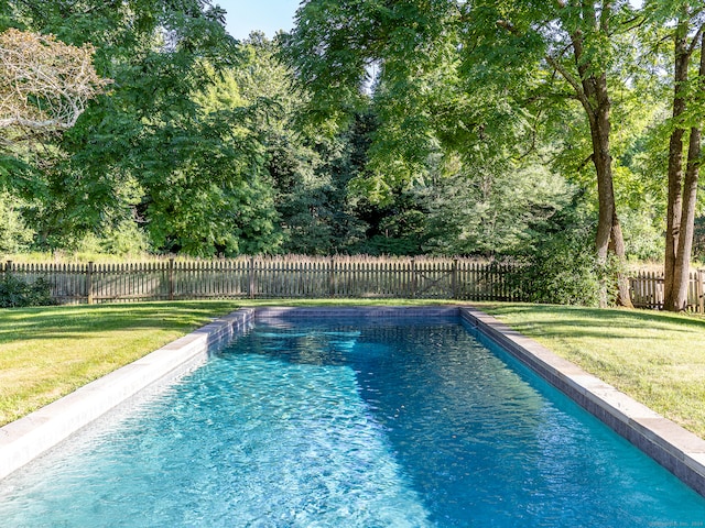 view of pool featuring a lawn