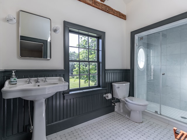 bathroom featuring tile patterned flooring, a shower with door, and toilet