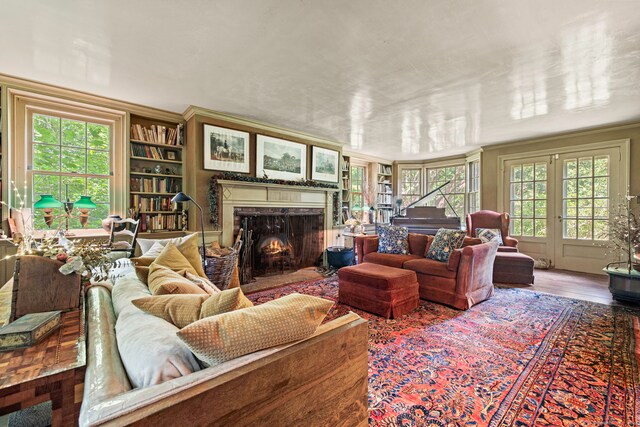 living room featuring a premium fireplace, hardwood / wood-style flooring, and crown molding