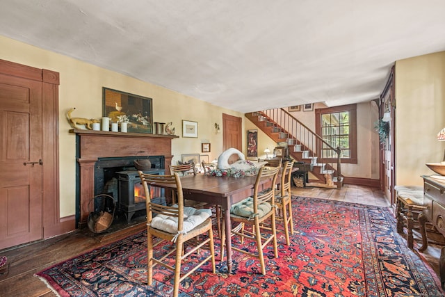 dining area with hardwood / wood-style floors and a wood stove