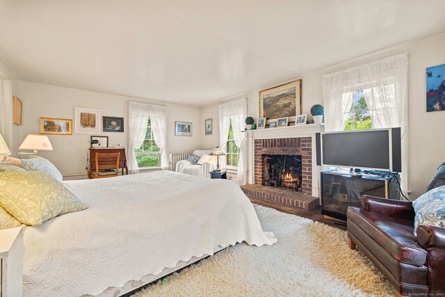 bedroom featuring a fireplace and multiple windows