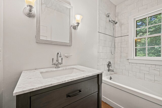 bathroom featuring vanity and tiled shower / bath combo