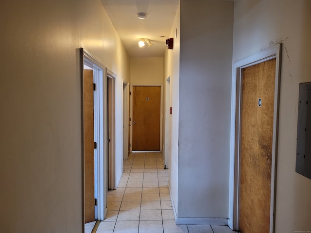 hallway featuring electric panel and light tile patterned floors