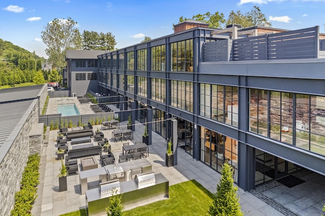 back of property featuring a pool and a patio area