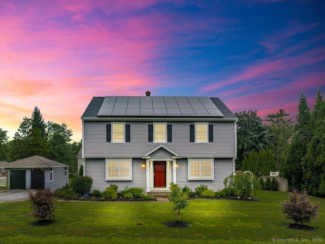 colonial house with a lawn and solar panels