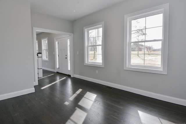 entryway featuring visible vents, a healthy amount of sunlight, dark wood-type flooring, and baseboards