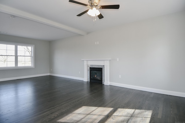 unfurnished living room with beam ceiling, a ceiling fan, dark wood finished floors, a premium fireplace, and baseboards