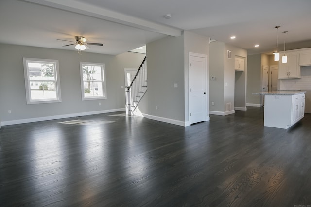 unfurnished living room with beamed ceiling, dark wood-type flooring, recessed lighting, baseboards, and stairs