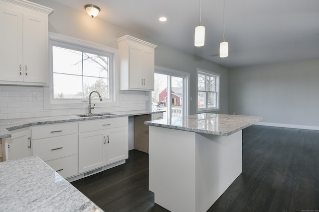 kitchen with dark wood-style floors, white cabinets, backsplash, and a sink