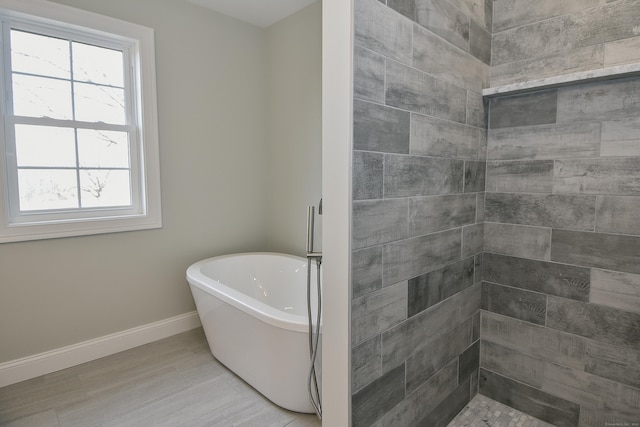 bathroom with a freestanding bath and baseboards