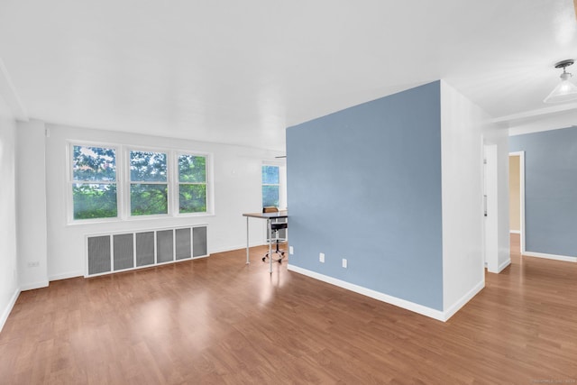 unfurnished living room with hardwood / wood-style flooring and radiator