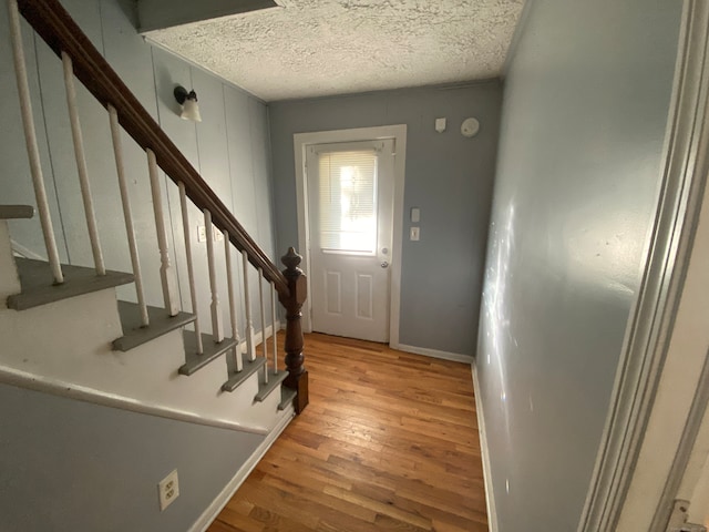 entrance foyer with light hardwood / wood-style floors and a textured ceiling