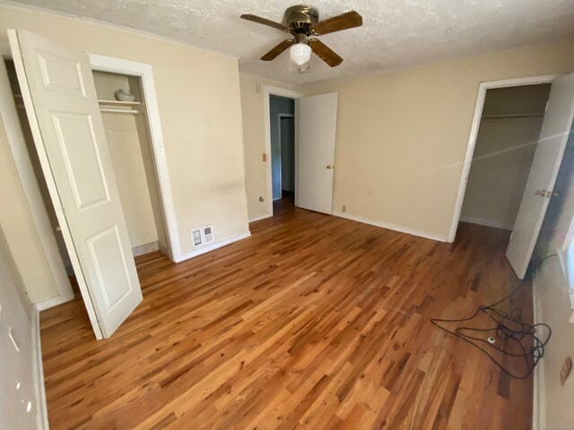 unfurnished bedroom featuring hardwood / wood-style floors, a textured ceiling, and ceiling fan